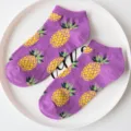 Detail view of purple low-cut boat socks featuring playful yellow pineapple pattern. - Pineapple / Purple Pineapple