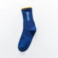 Detail view of stylish women's long crew socks featuring unique woven lettering and contrast cuffs. - One Size / Blue