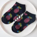 Detailed view of dark blue pineapple pattern cotton ankle boat socks placed on white plate. - Dark Blue Pineapple