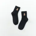 Schwarze gerippte Damensocken mit süßer brauner Bärenstickerei und welligem Bündchen. - Schwarz