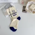 Beige mid-tube socks featuring cute blue smiley face and stylish letter print for women daily wear. - Milky White