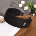 Serre-tête large en tricot noir pour femmes, anneau de cheveux uni avec étiquette en métal. - Noir