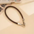 Detail view of dark brown PU leather wrist strap with sturdy silver metal double buckles and clasps. - Dark Coffee