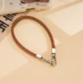 Brown PU leather short phone wrist strap with silver metal clasps, stylish accessory. - Brown