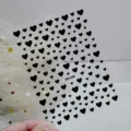 Gedetailleerd overzicht van 3D zwarte hart nagelstickers met zelfklevend ontwerp. - DH-540 / Zwart