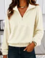 Close-up detail shot of women's half-zip fleece pullover showing lapel and cuff texture. - Apricot