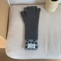 Vue détaillée de longs gants en tricot gris avec manchette à motifs et tissu chaud. - Taille unique / Gris Chiné