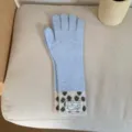 Gros plan de longs gants en tricot avec poignets à pois et étiquette tissée détaillée. - Taille unique / Bleu clair