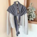 Vue détaillée du châle triangulaire en laine gris foncé à franges avec son cardigan. - Grande Écharpe Triangle à Franges / Gris Premium