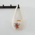 Détail de mini sac en tricot avec joli patch d'ours en peluche et bouton en bois. - Blanc Cassé
