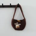 Détail de sac à main tricoté avec charmant patch de lapin et fermeture à bouton en bois. - Café