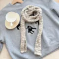 Gros plan d'une écharpe tricotée rayée douillette, accessoire de mode texturé. - Baguette à Pois / Largeur 9cm / Kaki Clair
