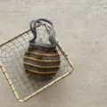 Gros plan d'un sac à main tricoté rayé élégant en gris et jaune avec de la laine texturée. - Rayures Bicolores / Jaune Gris