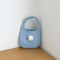 Vue détail d'un sac à main en tricot bleu clair avec un charmant pompon duveteux. - Bleu