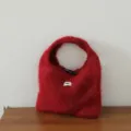 Vue de détail de sac à main en tricot mohair pelucheux rouge, avec fermeture bouton et étiquette. - Cuivre Rétro