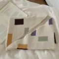 Détail d'écharpe en tricot à blocs de couleur avec motifs géométriques et texture douce. - Beige