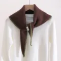 Vue détaillée du foulard triangulaire en tricot marron avec bordure verte et étiquette. - Bleu Géométrique / Café