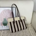 Vue détaillée du sac cabas en tricot rayé avec poignées en cuir et fermeture éclair. - Rayures Noir Beige / M