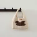 Vue détaillée du sac à main tricoté d'automne hiver avec motif lapin marron et bouton en bois. - Kaki
