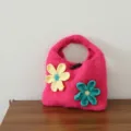 Gros plan détaillé du sac à main en tricot rose avec fleurs crochetées et fermeture à genouillère. - Bouton Olive Fleur / Rose rosé