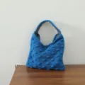 Vue détaillée du sac à main en tricot bleu, design texturé à pois, style cabas tendance. - Sac à Pompons / Bleu Klein