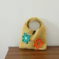 Gros plan détail d'un sac à main tricoté à la main avec fleurs 3D colorées, accessoire de mode hiver - Bouton Olive Fleur / Curcuma