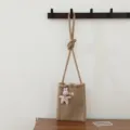 Détail en gros plan du sac bandoulière en tricot marron avec pendentif lapin en peluche style. - Sac Bandoulière Lapin / 1 Pièce / Kaki