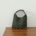 Gros plan de la texture du sac à main tricoté vert foncé, montrant le motif de perles 3D. - Sac à Pompons / Vert Foncé