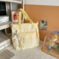 Cute yellow and white striped canvas tote bag with front pocket and handles for daily use. - Shoulder Bag with Pendant / Yellow