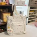 Casual white canvas shoulder bag with colorful doodle print, multiple pockets and straps. - Tutoring Bag with Smiling Star Pendant / White