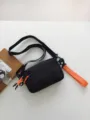 Black crossbody bag for men and women, casual lightweight shoulder bag with orange details. - Orange
