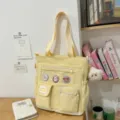 Borsa tote in tela gialla con tasca trasparente, variante di borsa scolastica casual. - Giallo Con Ciondolo