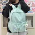 Detail view of the cute star print student backpack with cute rabbit ears and a pom-pom charm. - Large (With Pendant) / Green