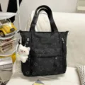 Black star print tote bag with plush bear pendant and dual top handles, spacious interior. - Tutoring Bag with Greedy Bear / Black