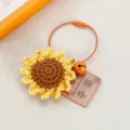Primo piano di un portachiavi girasole all'uncinetto con anello in cavo e campanello. - Ciondolo Finito (Punteggio Massimo)