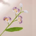 Primo piano di un ramo di fiori di falenopsis all'uncinetto fatto a mano con filato. - Viola