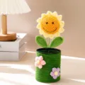 Gedetailleerd overzicht van een handgehaakte zonnebloem penhouder met lachend gezicht voor bureau. - Smiley