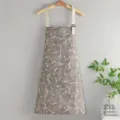 Vista detallada del delantal de cocina impermeable con estampado floral ajustable. - Pata de Gallo Marrón