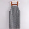 Delantal de cocina impermeable gris con tirantes cruzados marrones y bolsillos dobles. - Correa De Cuero Extendida Gris