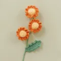 Dettaglio di margherita all'uncinetto fatta a mano, squisiti fiori lavorati a maglia per casa. - Arancione