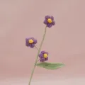 Detailed view of handmade crochet purple puff flower branch, delicate stem and green leaf. - Flower Purple