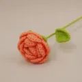 Handmade crochet rose flower variant featuring vibrant orange petals and green stem leaf. - Orange