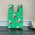 Vista dettagliata di una borsa in maglia verde con un motivo festivo di calze natalizie e fiocchi. - Taglia S / Stivale di Natale - Verde
