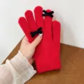 Close-up detail of red knitted gloves with elegant black velvet bows for winter. - One Size / Red