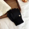 Detailed shot of black knit gloves featuring a cute embroidered bear, soft winter warm mittens. - One Size / Black