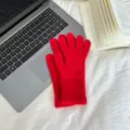 Detailed close-up of vibrant red fluffy winter touchscreen gloves with warm knit texture. - One Size / Red