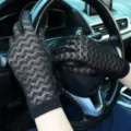 Detail view of black floral lace gloves for women, sheer design for summer UV protection. - One Size / Black