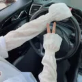 Detailed view of white ruffled sun protection sleeves for outdoor driving and riding comfort. - One Size / White