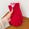 Dettaglio di guanti in maglia rossa da donna con simpatiche orecchie da coniglio. - Taglia unica / Rosso