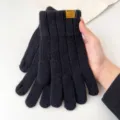 Close-up detail shot of winter knitted touch screen gloves in black with cuff label accent. - One Size / Black